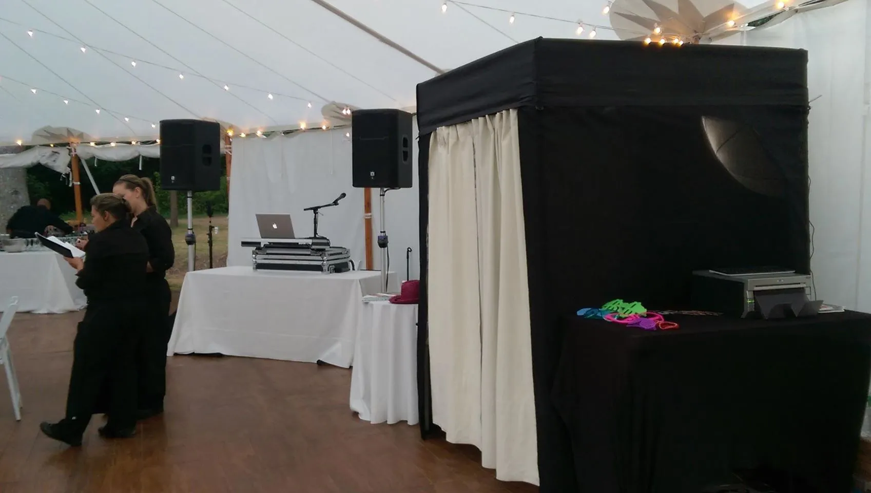 Guests using an enclosed photo booth during a lively Worcester event