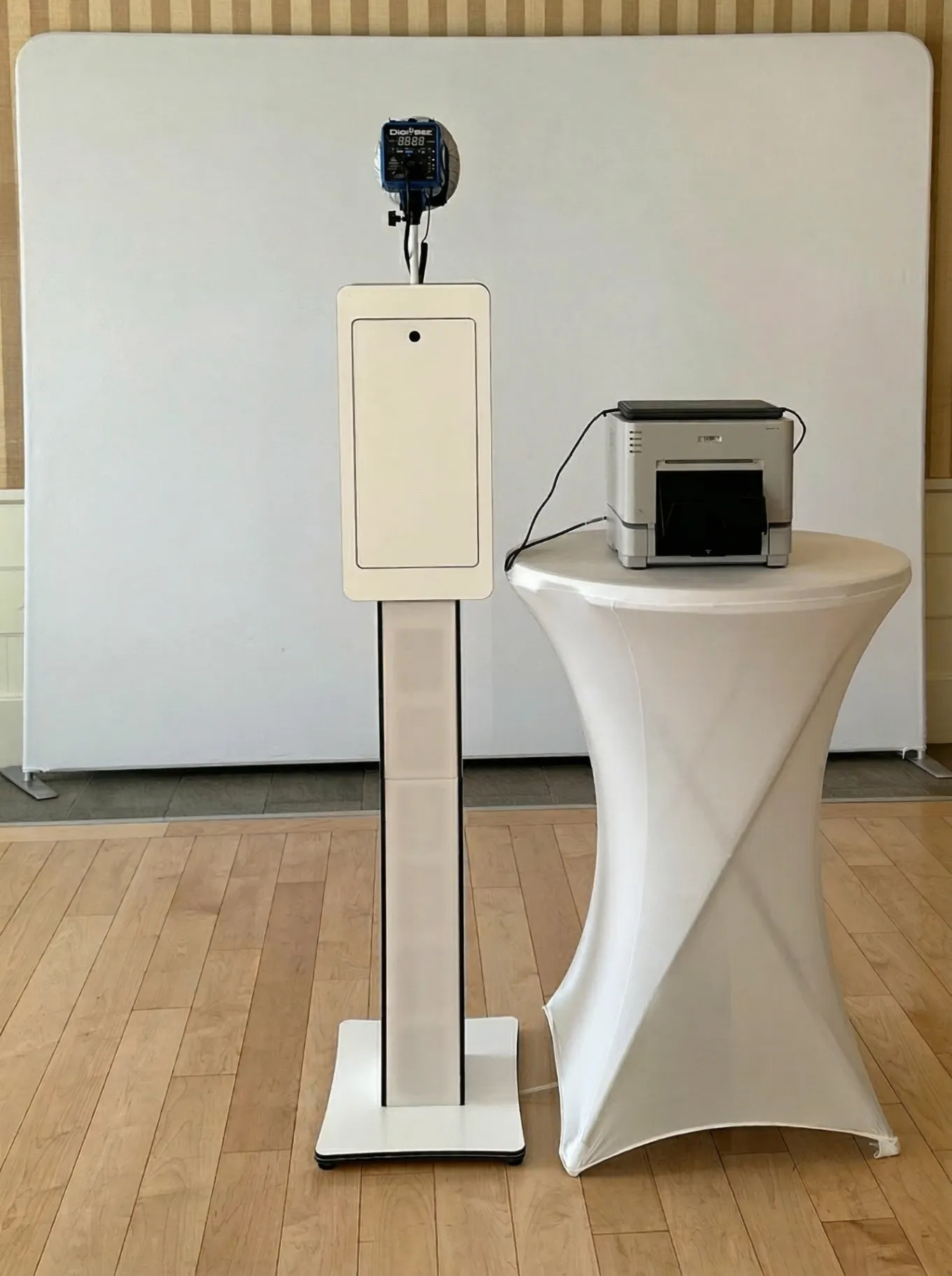 Allure Booth setup with stand, camera, backdrop, and printer at an event venue
