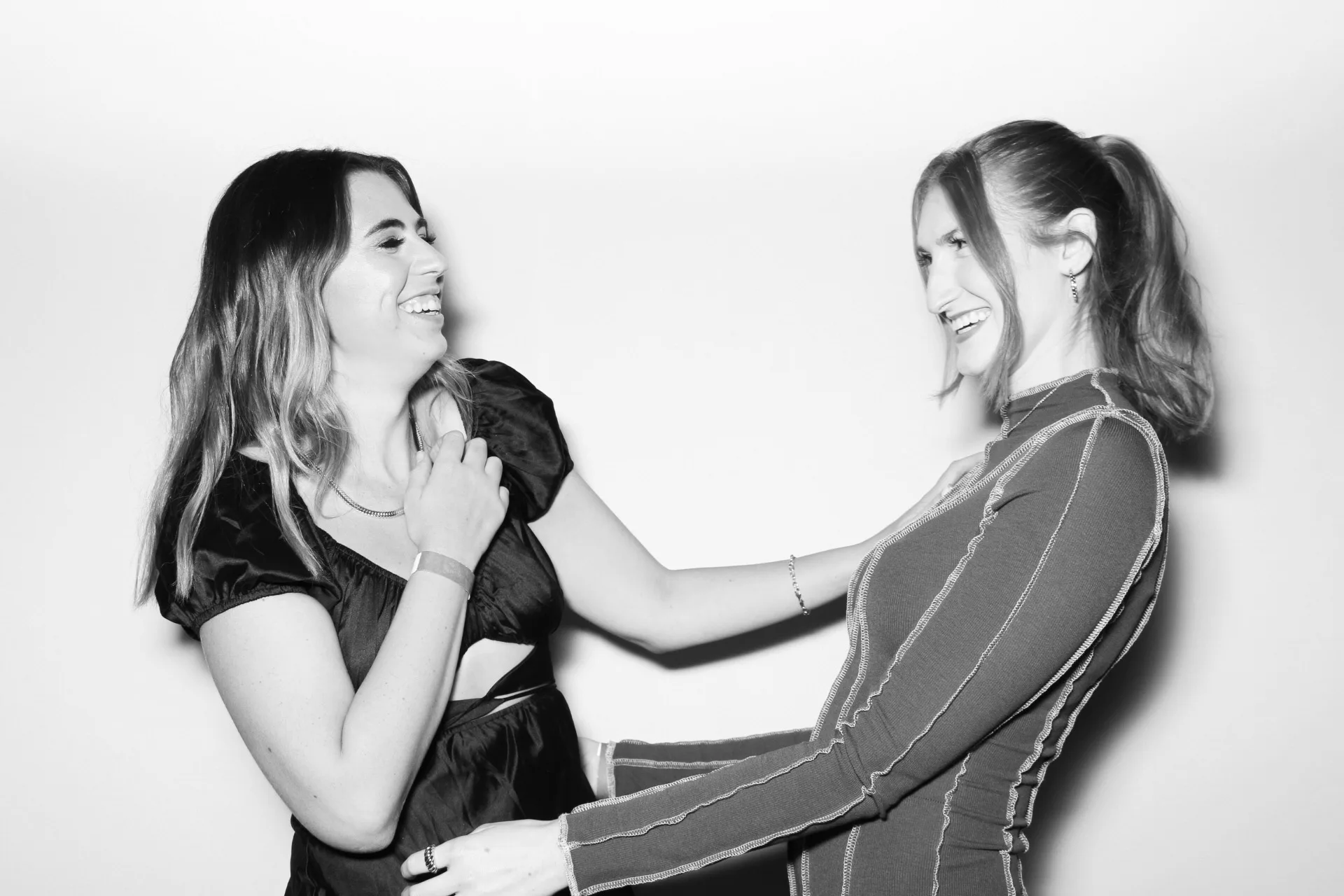 Allure Booth black and white candid portrait of two friends sharing a laugh