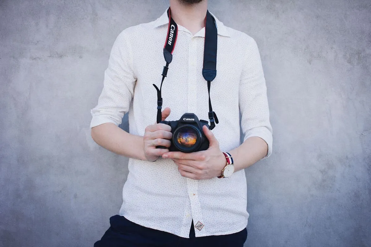 Event photographer with a DSLR camera capturing candid guest portraits at an event