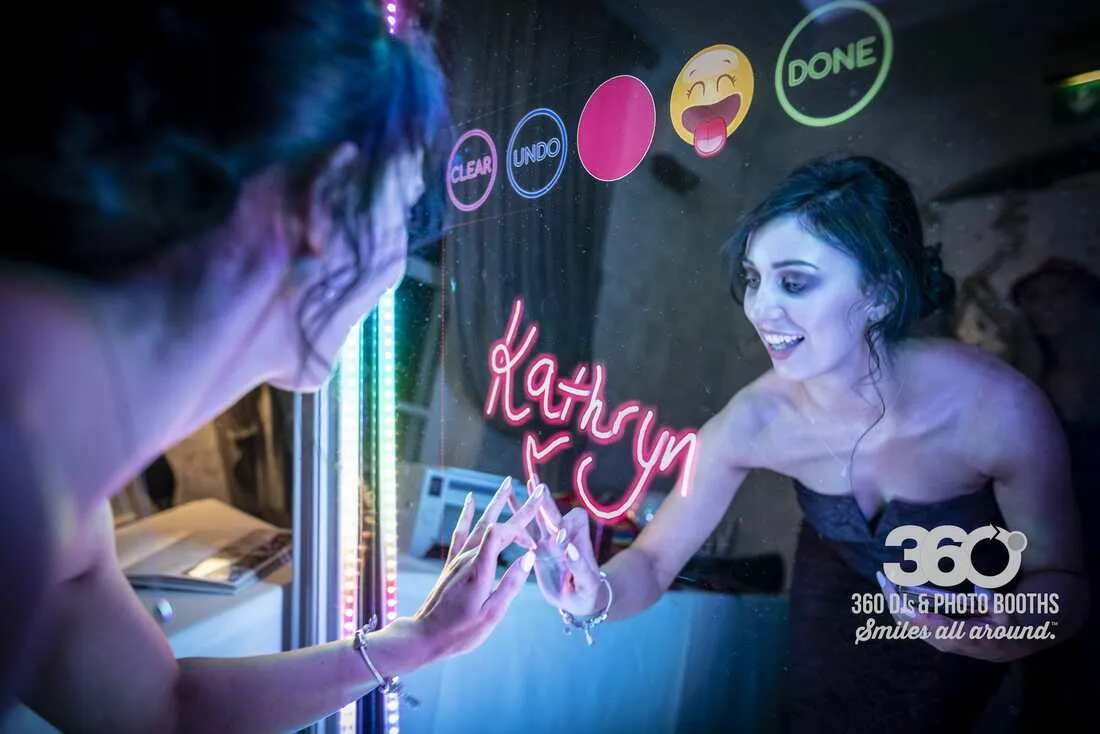 Selfie Mirror guest signing the screen with digital neon handwriting effects