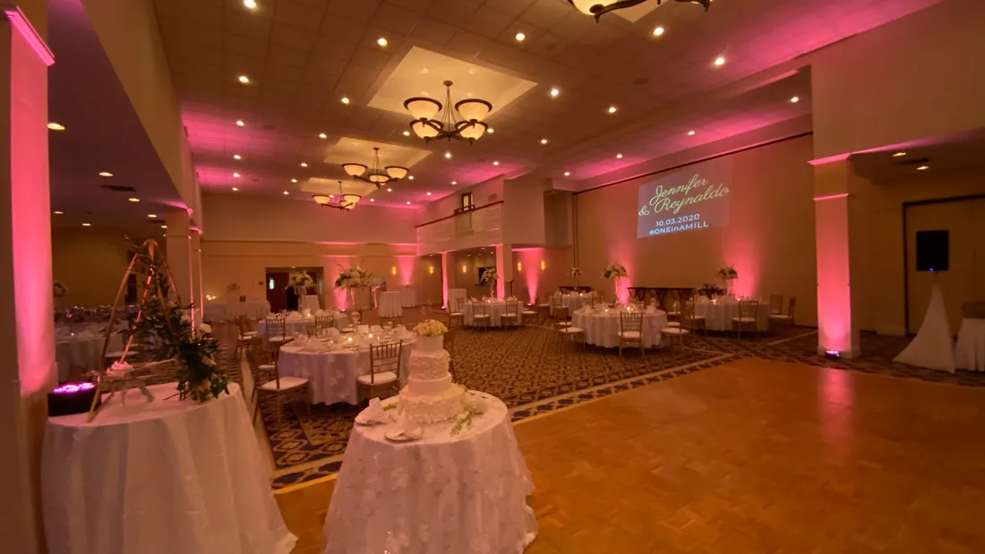 pink uplighting around a ballroom dance floor and reception space